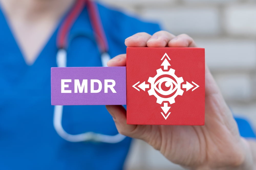 Young female doctor holding colorful blocks with banner: EMDR. Medical concept of EMDR Eye Movement Desensitization Reprocessing. EMDR therapy.